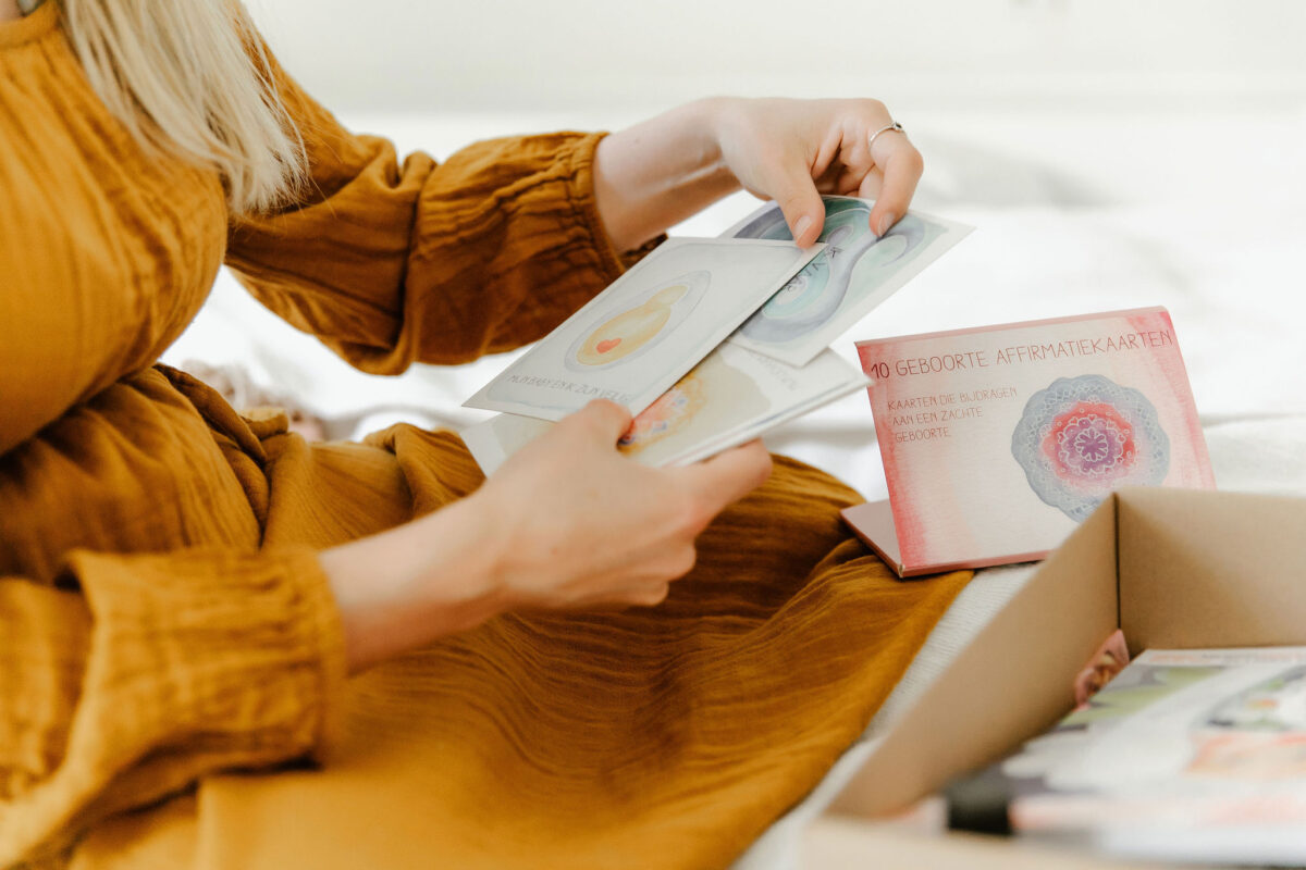 zwangere vrouw bekijkt affirmatiekaarten