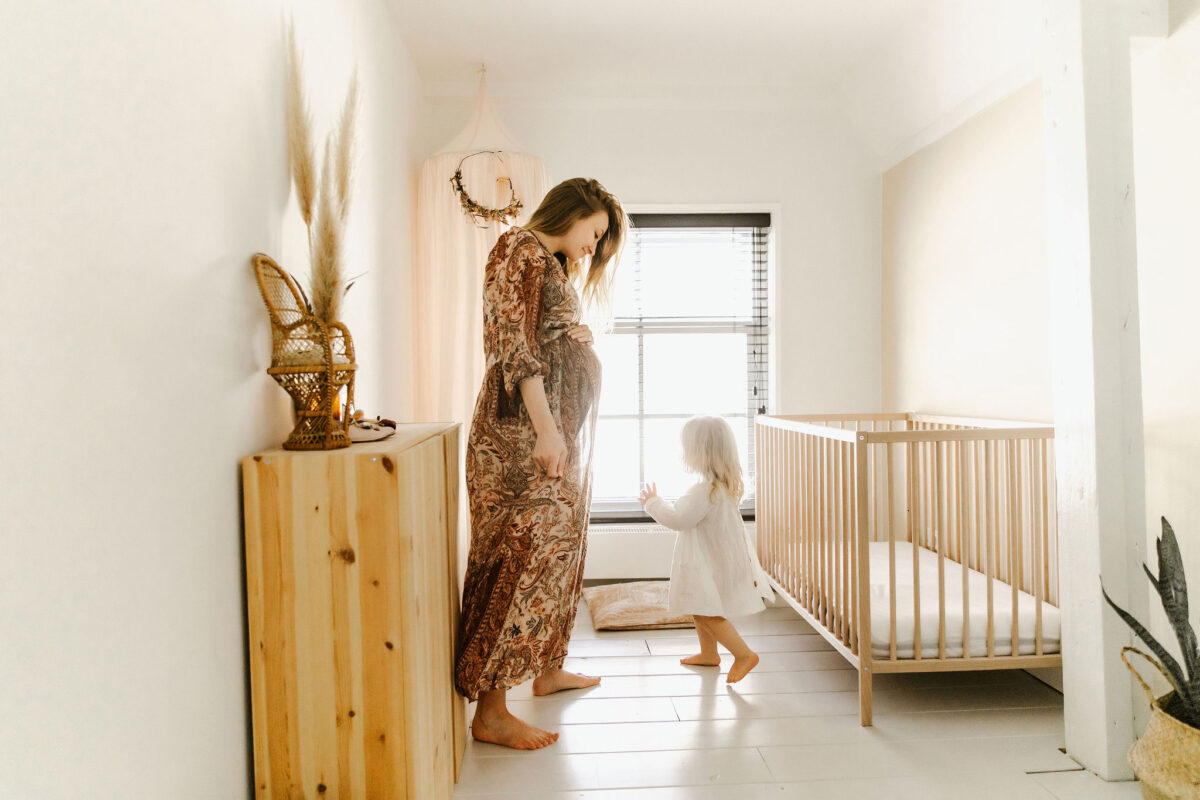 zwangere vrouw met kind in babykamer