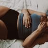 vrouw ligt in onderbroek op bed